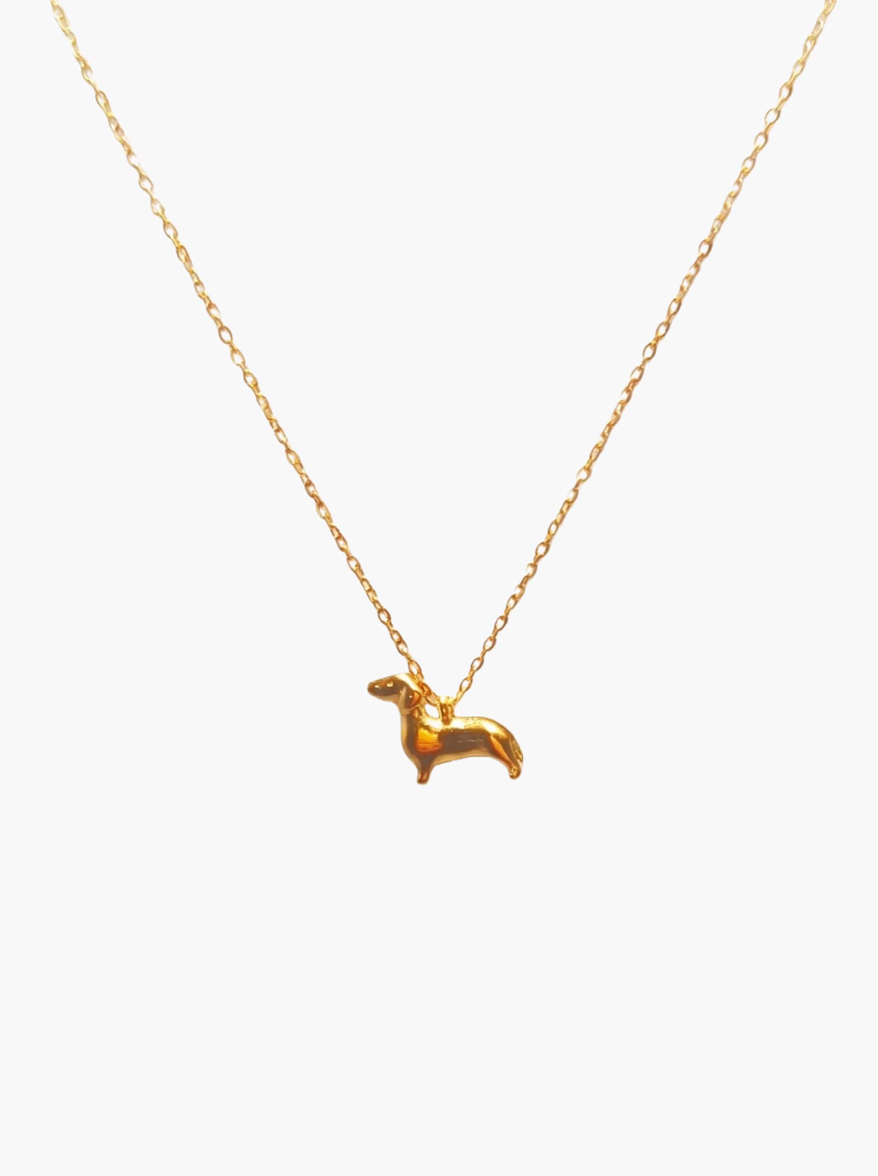 gold dachshund necklace against a white background