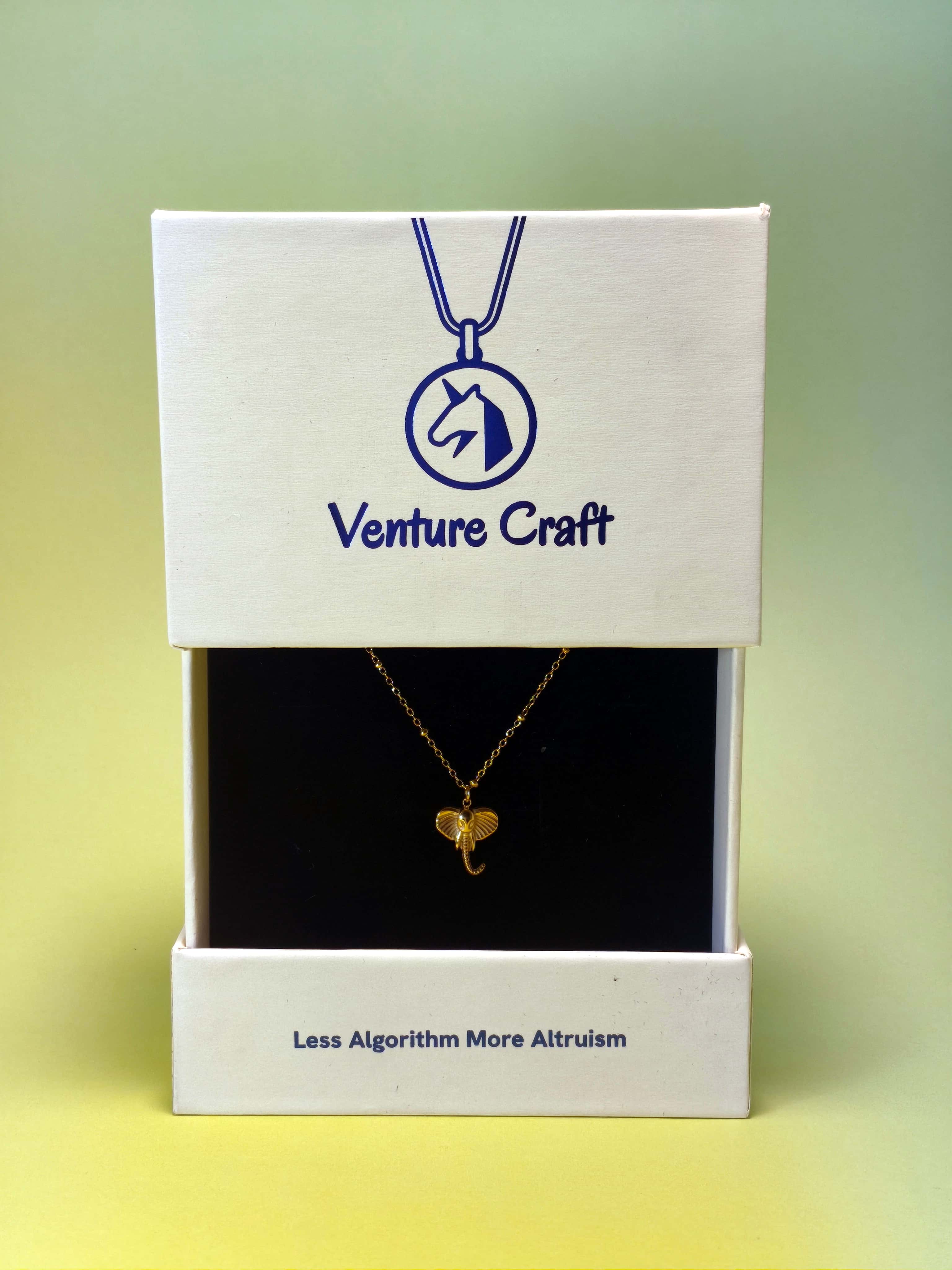 gold elephant pendant necklace in a Venture Craft gift box on a gradient background
