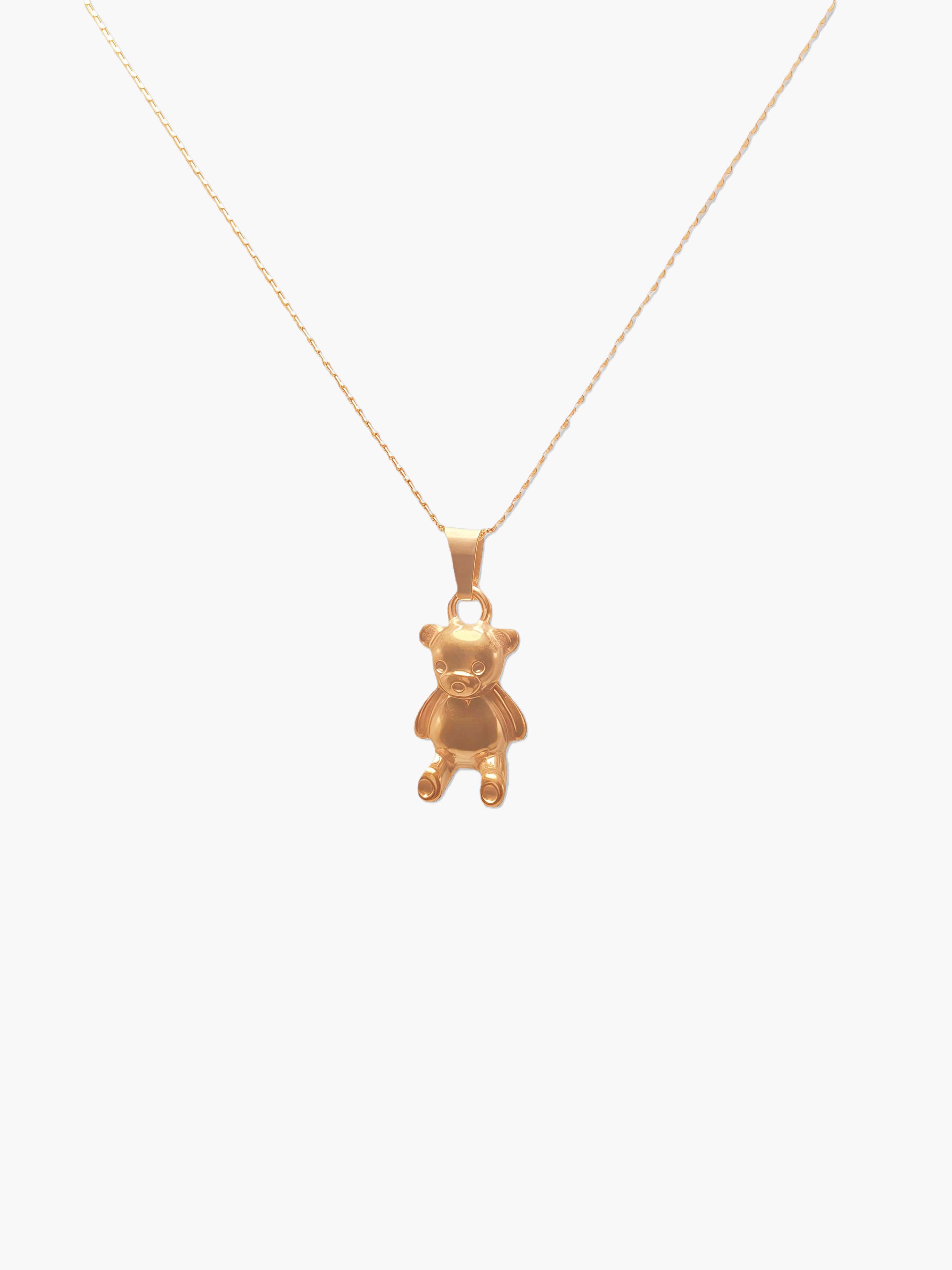 gold teddy bear pendant necklace against a white background