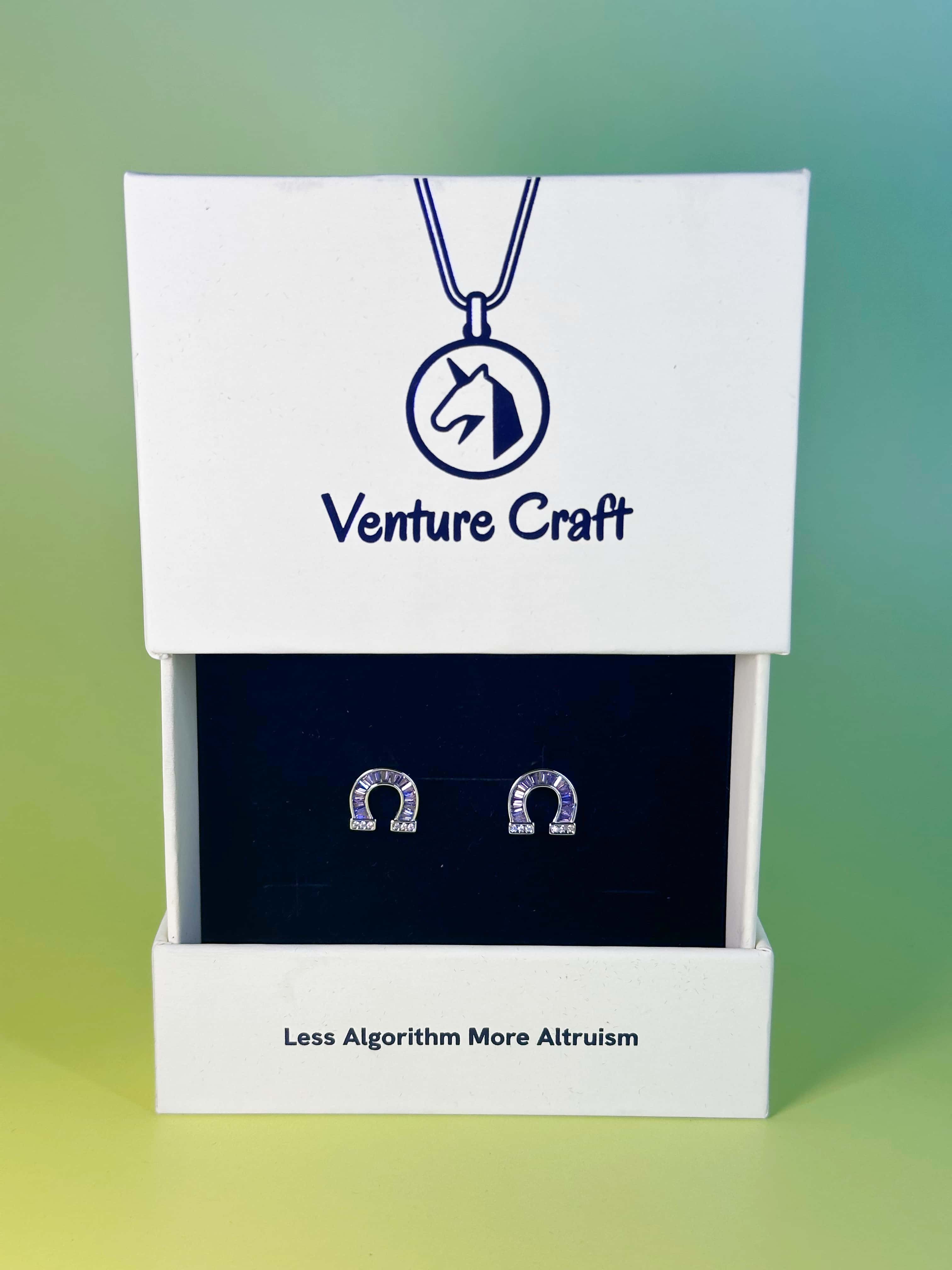 Luxury white and blue Venture Craft gift box packaging displaying the sparkling diamond horseshoe earrings inside